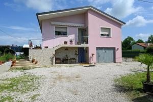 een roze huis met een balkon in een tuin bij Piazzola holiday home * * * * * 