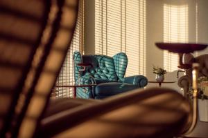 a blue chair sitting in a living room next to a window at Sea Star Budva in Budva