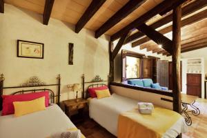 a bedroom with two beds in a room with wooden ceilings at Casa María in Santa Maria del Camí