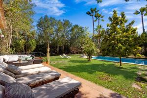 a backyard with a swimming pool and a lawn at Casa María in Santa Maria del Camí