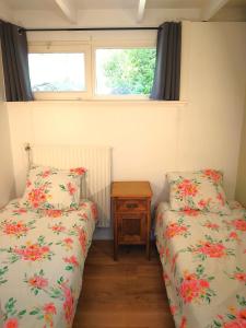 - 2 lits dans une petite chambre avec fenêtre dans l'établissement Zonnige vrijstaande bungalow in prachtige omgeving!, à Rekem