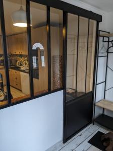 Cette chambre dispose de portes vitrées et d'une cuisine. dans l'établissement Agréable maison de ville rénovée à Rouen, à Sotteville-lès-Rouen