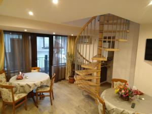 a dining room with a table and a spiral staircase at La Cristina in Slatina