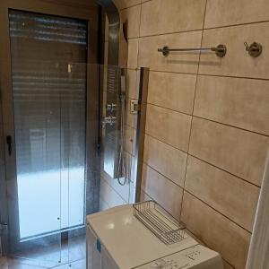 La salle de bains est pourvue d'une douche en verre et d'un lavabo. dans l'établissement Olive and Aloe Villas, à Nomikianá