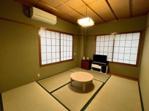 a room with a table and a tv and windows at Yuzawa House - Vacation STAY 07072v in Yuzawa