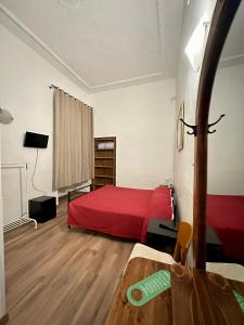 a bedroom with a red bed and a wooden floor at Hotel Il Papavero in Rome