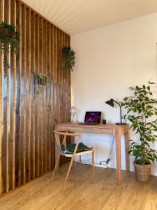 een houten bureau met een laptop naast een plant bij Design-Apartment in Langenbach