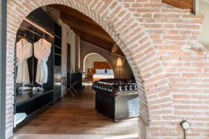 ein gemauerter Torbogen mit einer Lederbank in einem Zimmer in der Unterkunft Pavillon Suite in Peschiera del Garda