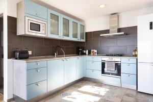 una cucina con armadi blu e forno a microonde di EK Teide Finca el Milagro a La Orotava Altre 48 foto