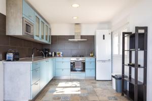 eine Küche mit blauen Schränken und einem weißen Kühlschrank in der Unterkunft EK Teide Finca el Milagro in La Orotava