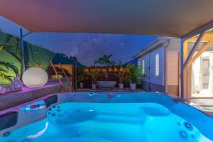 a hot tub in the backyard of a house at Magnifique Bungalow et Jacuzzi au cœur des plages in Le Moule
