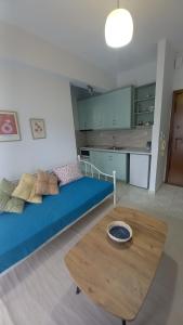 sala de estar con cama azul y mesa de madera en TasoulaSHome en Komotini