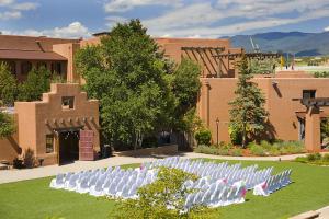 a row of white chairs in front of a building at The Lodge at Santa Fe in Santa Fe