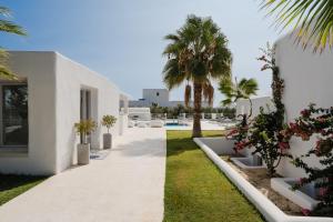 a white house with palm trees and a pool at White Dunes Luxury Boutique Hotel in Santa Maria