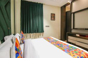 a bedroom with a bed and a tv at FabHotel Prime K9 Crown in Ludhiana
