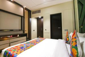 a bedroom with a bed and a flat screen tv at FabHotel Prime K9 Crown in Ludhiana