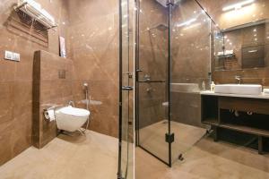 a bathroom with a shower and a toilet and a sink at FabHotel Prime K9 Crown in Ludhiana