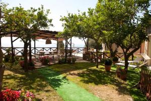 een tuin met een tafel, stoelen en bomen bij Tessa's holiday in Massa Lubrense