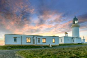 ウィックにあるSelf-catering Lighthouse Keeper's Cottage on the NC500の夕日灯台前の家