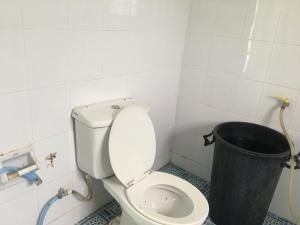 a bathroom with a toilet and a trash can at LungYod guesthouse in Ban Tha Ling Lom