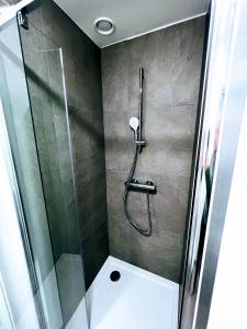 a shower with a glass door next to a toilet at Éclat Bruxellois - Modernité & Vue - Proche Atomium! in Brussels