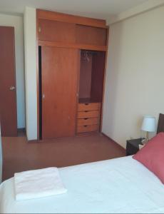 sypialnia z łóżkiem i szafą z białą narzutą w obiekcie Las Mercedes w mieście Arequipa
