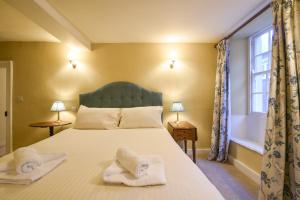 a bedroom with a bed with towels on it at Malabar House in Lyme Regis