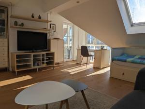 sala de estar con sofá y TV en Ruhige 3-Zimmer-Wohnung am Stadtrand mit Bergblick, en Salzburgo