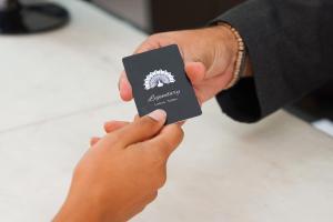 une personne détenant une carte noire entre ses mains dans l'établissement Legendary Lisboa Suites, à Lisbonne