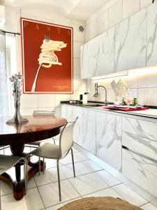 アスティにあるComeCasa Alfieri Elegant Apartmentの木製テーブルと赤い絵画付きのキッチン