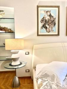 a bedroom with a bed and a table with a lamp at ComeCasa Alfieri Elegant Apartment in Asti