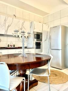 アスティにあるComeCasa Alfieri Elegant Apartmentのキッチン(木製テーブル、冷蔵庫付)