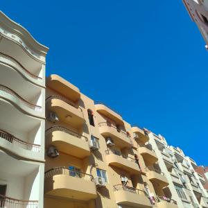 a tall apartment building with balconies and a blue sky at Hurghada City Apartment1 in Hurghada
