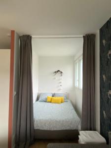 1 dormitorio con 1 cama con almohadas amarillas en Appartement BIENVENUE au calme quartier Venoix en Caen