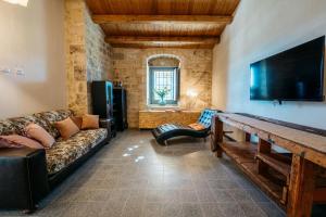 a living room with a couch and a flat screen tv at Villa Torre Molino - IsulaTravel in Modica