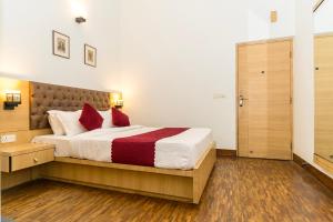 um quarto com uma cama grande e almofadas vermelhas em Hotel Blue Poppy em Gangtok