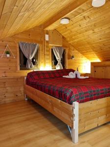 una camera con un letto in una baita di tronchi di Chalet Belvedere a Pieve Tesino