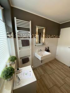 ein Bad mit einem Waschbecken und einem Spiegel in der Unterkunft Ferienwohnung Ambiente II und III in Klotten