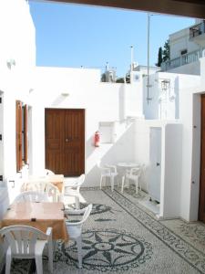 a patio with tables and chairs on a white building at SunStudios in Líndos