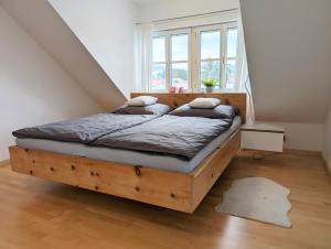 a bedroom with a wooden bed in front of a window at Ruhige 3-Zimmer-Wohnung am Stadtrand mit Bergblick in Salzburg