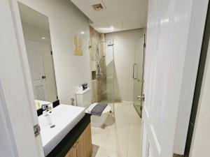 a white bathroom with a sink and a shower at The Lago Naiharn by Sala Estate in Nai Harn Beach