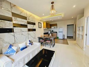 un soggiorno con divano bianco e una cucina di The Lago Naiharn by Sala Estate a Nai Harn Beach