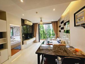 a kitchen and living room with a table and chairs at The Lago Naiharn by Sala Estate in Nai Harn Beach