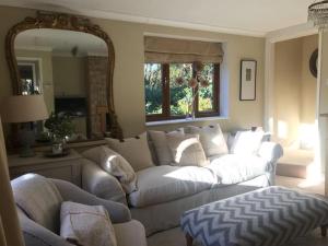 a living room with a white couch and a mirror at Rural house 2BR 4 person 20 min f/beach, Rolvenden in Rolvenden
