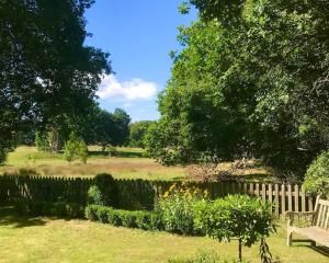 a park with a wooden fence and a bench at Rural house 2BR 4 person 20 min f/beach, Rolvenden in Rolvenden