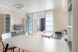 sala de estar con mesa blanca y sofá en One Bedroom Apartment Near Arbat In The Center of Almaty, en Almaty