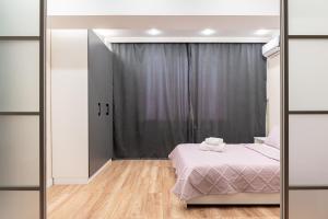 a bedroom with a bed and a mirror at One Bedroom Apartment Near Arbat In The Center of Almaty in Almaty