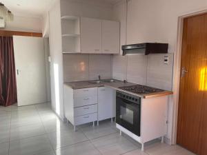 a kitchen with white cabinets and a stove top oven at De la posh Travels and tours in Windhoek