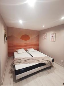 1 dormitorio con 1 cama y una pintura en la pared en LaMaisonnette_au_36 en Angoulême