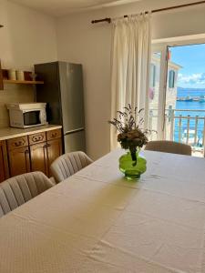 uma cozinha com uma mesa com um vaso de flores em Villa Adria em Vodice